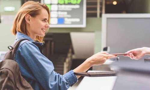 Traveller handing over her passport at an airport check-in counter
